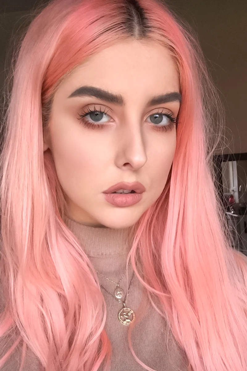 a portrait of a beautiful woman with a peachy pink hair