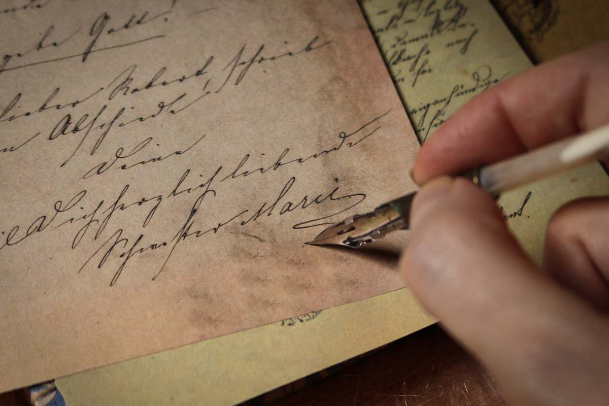 quill writing on a piece of yellow paper