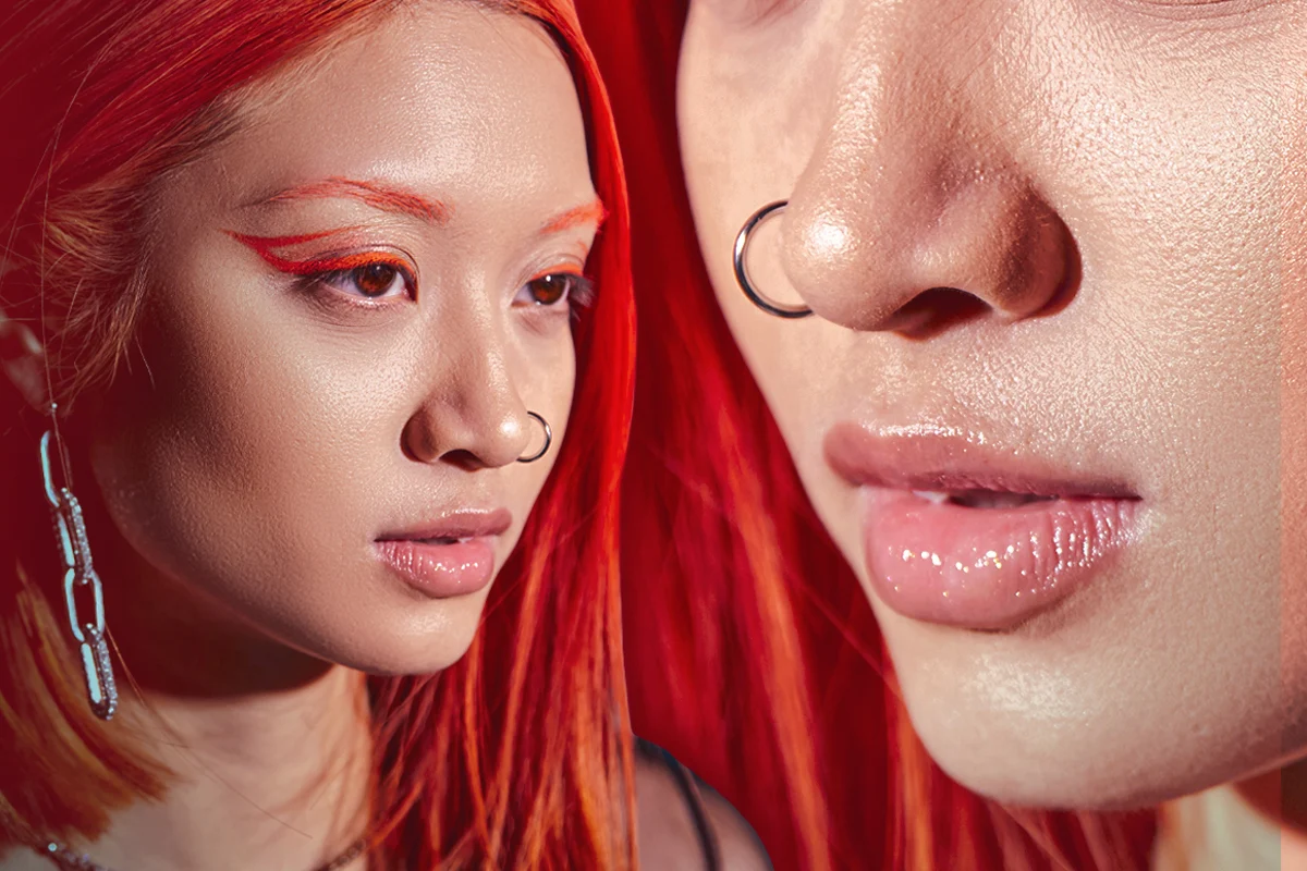 A PORTRAIT OF A woman with a face piercing and makeup